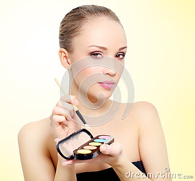 Attractive girl with makeup palette