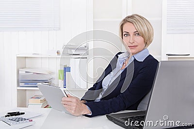 Attractive happy older or senior business woman in the office.