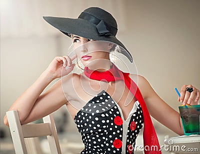 Attractive lady with black hat and red scarf sitting in restaurant