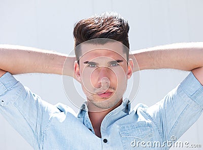 Attractive male fashion model with hands behind head