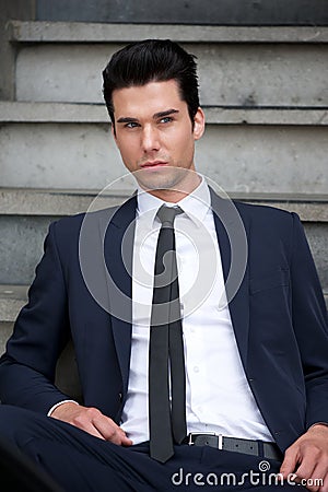 Attractive male fashion model sitting on stairs