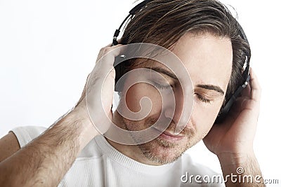 Attractive man with headphones in front of a white background en