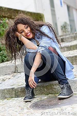 Attractive mixed woman in urban background wearing casual clothe