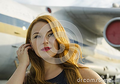 Attractive redhead woman about aircraft outside happy to travel