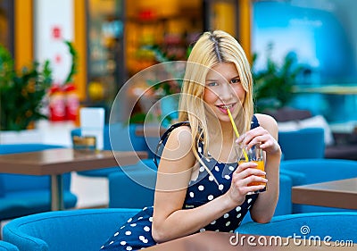 Attractive teen girl drinking juice in bar