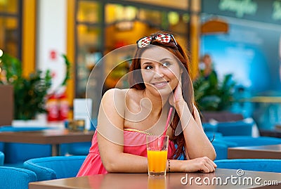 Attractive teen girl drinking juice in bar