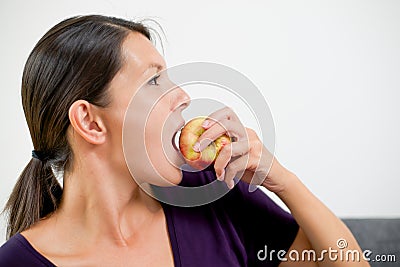 Attractive woman biting a fresh red apple