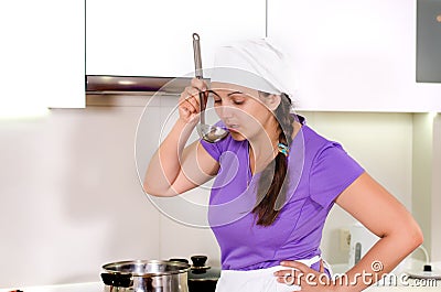 Attractive woman chef standing tasting the food