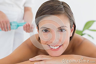 Attractive woman getting massage oil on her back