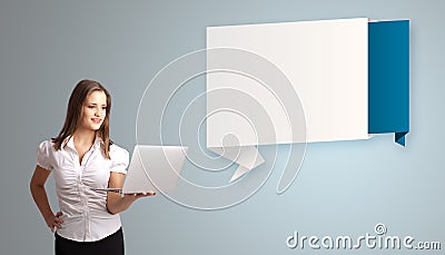 Attractive woman holding a laptop and presenting modern origami