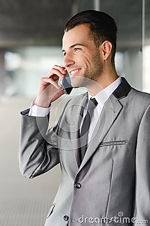 Attractive young businessman on the phone in an office building