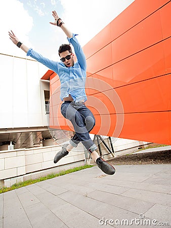 Attractive young male model jumping outdoors
