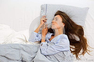 Attractive young woman asleep in bed