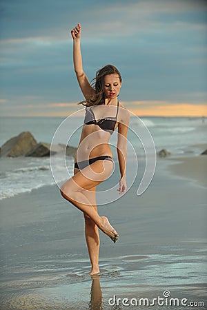 An attractive young woman in bikini posing on the beach