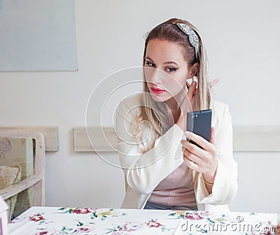 Attractive young woman in the restaurant holding lipstick and lo