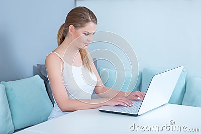 Attractive young woman using a laptop at home