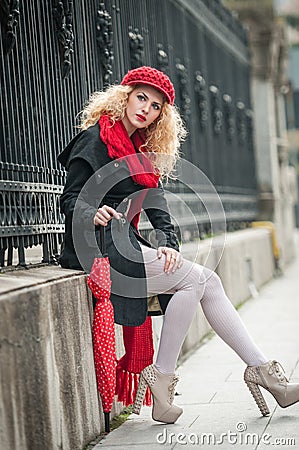 Attractive young woman in a winter fashion shot. Beautiful young girl with red umbrella in the street