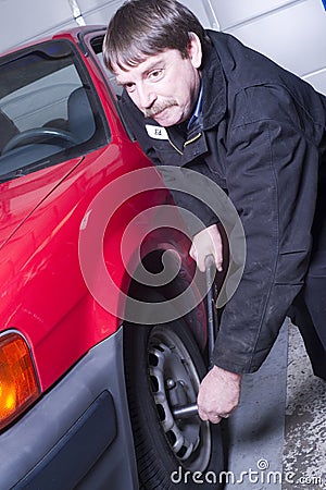 Automotive Technician Auto Mechanic Loosens Lug Nut Front Tire