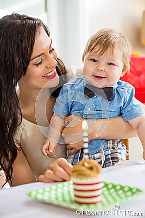 Baby Boy And Mother With Birthday Cake On Table