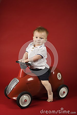 Baby boy sitting on play car.
