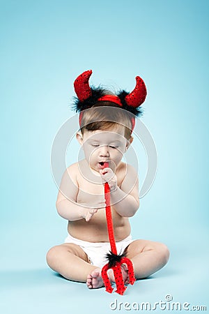 Baby with devil horns on blue background