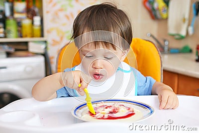 Baby eating semolina porridge with jam