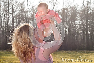 Baby flying in nature when mommy is holding her