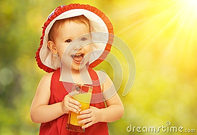 Baby girl drinking orange juice in the summer