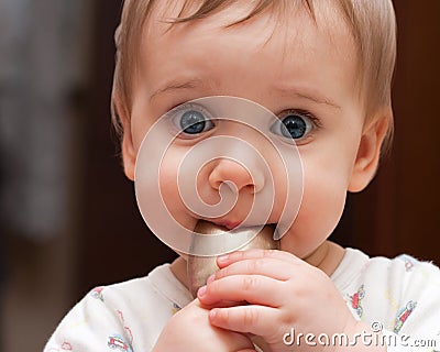 Baby girl holding spoon in mouth