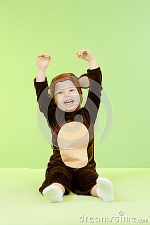 Baby girl in monkey costume over green background