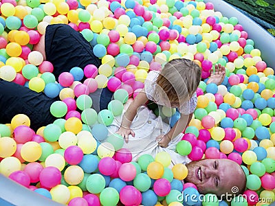 Baby girl playing in a pool of balls