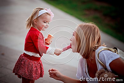 Baby girl sharing ice-cream with mother