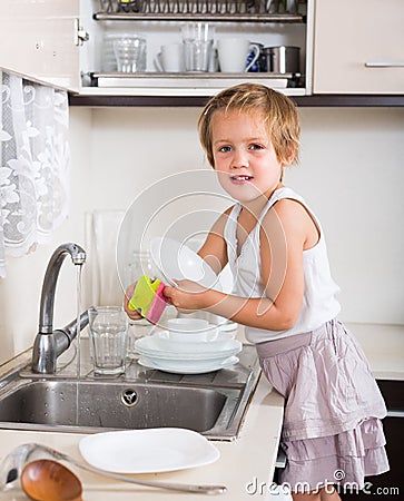 Baby girl washing dishes