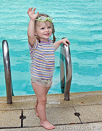 Baby in goggles leaves pool.