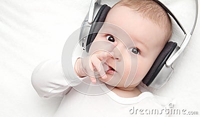 Baby with headphone lies on back