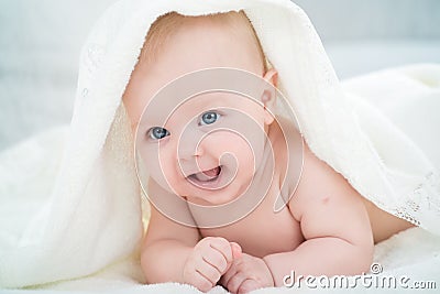 Baby looking at camera under a white blanket