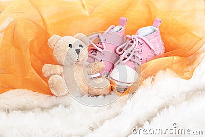 Baby pink shoes and teddy bear