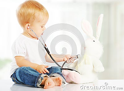 Baby plays in doctor toy bunny rabbit and stethoscope