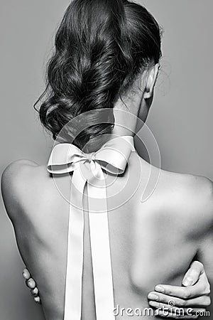 Back of beautiful gentle girl with silk bow on the neck