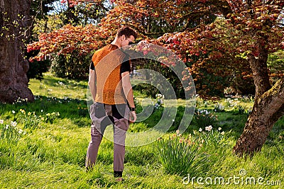 Back of man in front of a tree in park