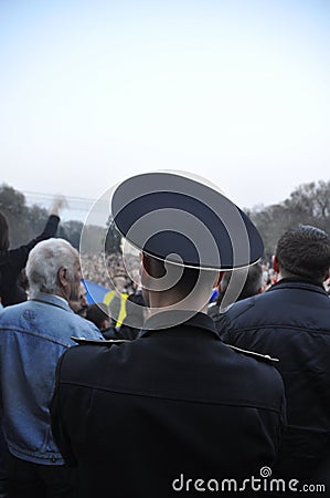 Back of a police man looking at the protest