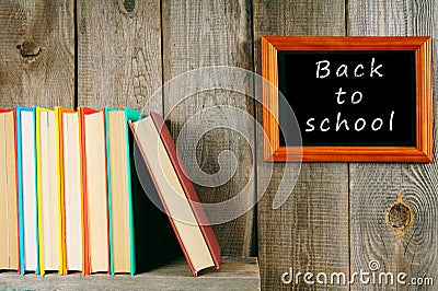 Back to school. Books on wooden shelf and frame.