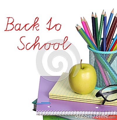 Back to school concept. An apple, colored pencils and glasses on pile of books isolated on white background.