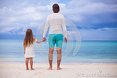 Back view of little girl hugging with dad on the