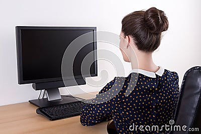 Back view of young beautiful business woman using pc with empty