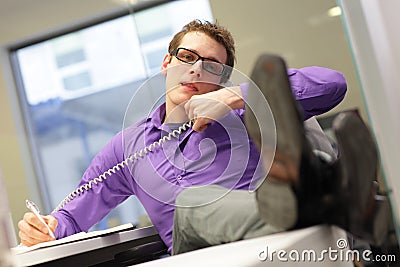 Bad sitting posture - business man in his office on phone