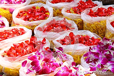 Bags of red and purple colored orchid petals and yellow marigold for Chinese ceremony