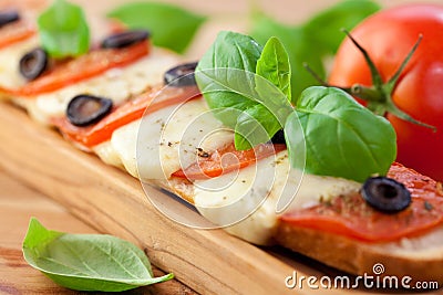 Baked baguette with mozzarella and tomatoes