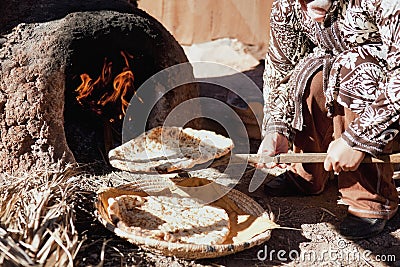 Baking traditional bread in a natural clay oven.