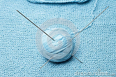Ball of blue wool with steel needles